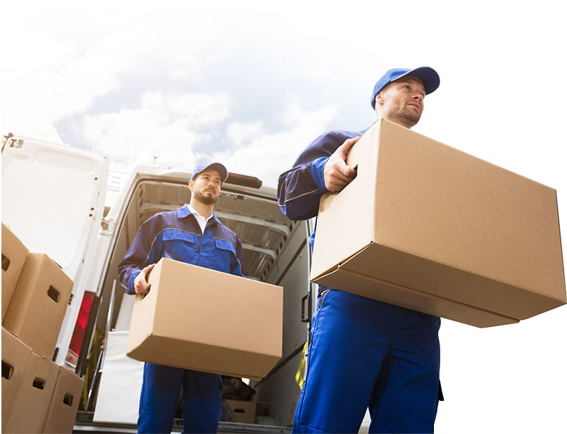 Two adult males carrying moving boxes out of the removal van